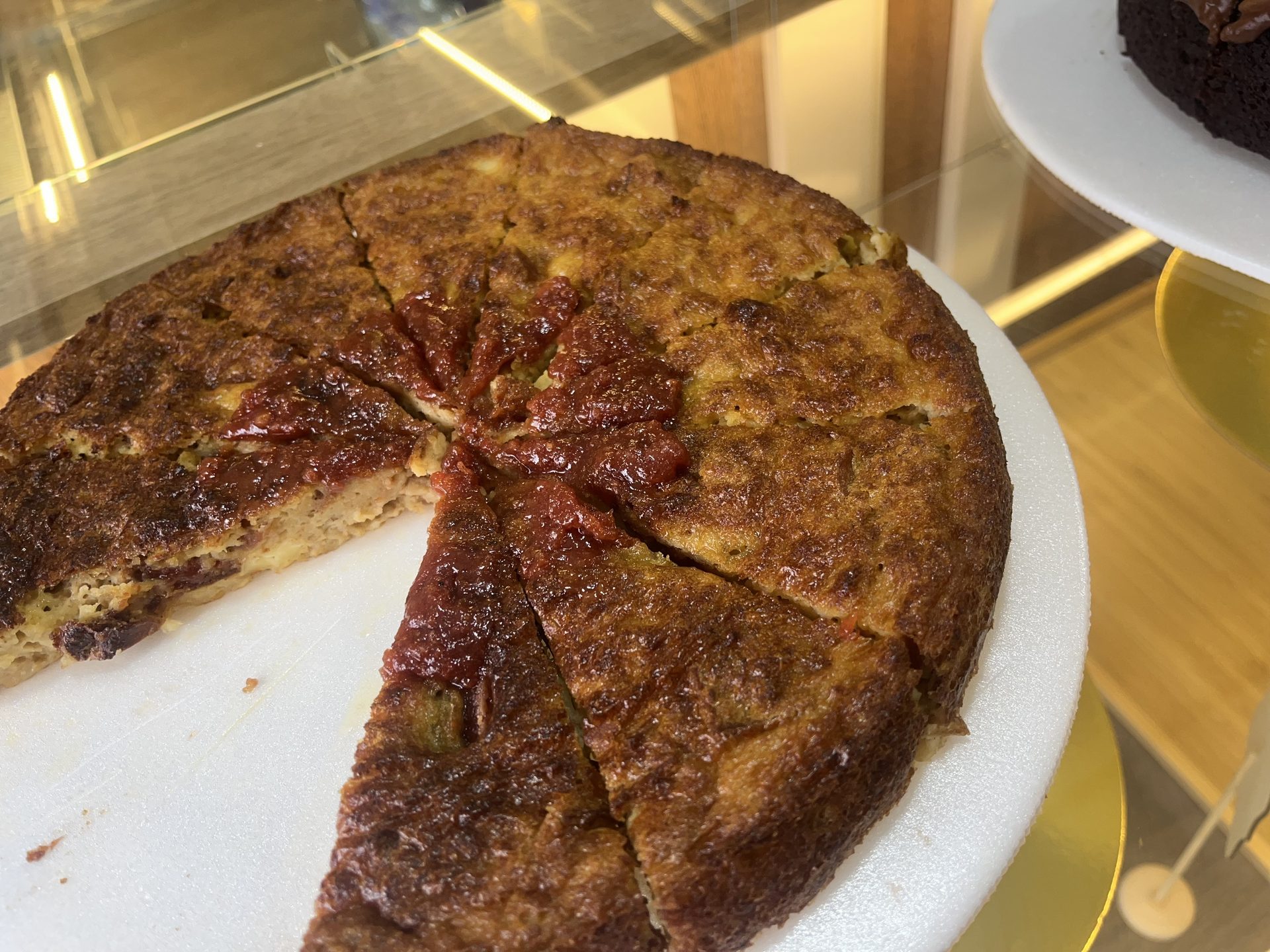 Torta de almojábana dorada, con una porción cortada