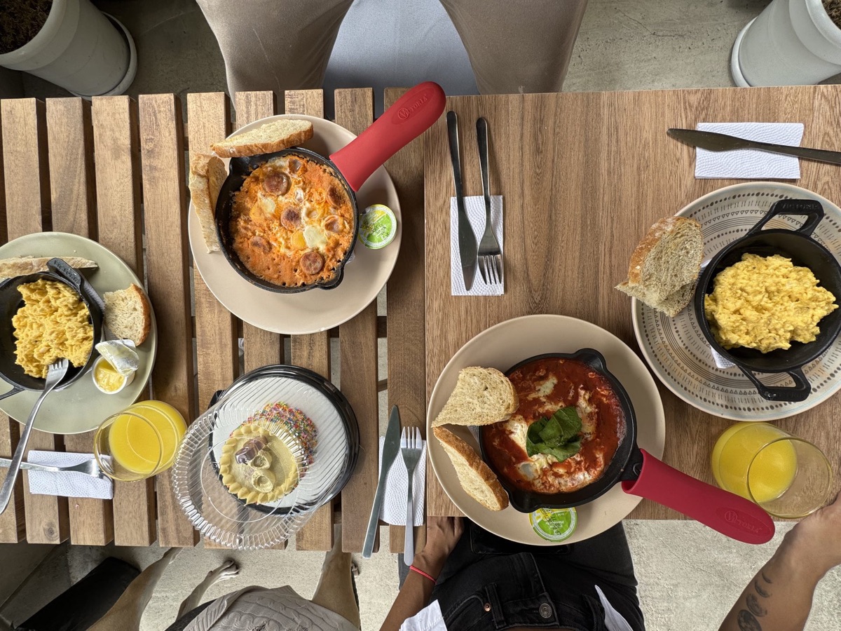 Mesa de brunch con huevos, pan y café